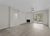 Thumbnail 3 of 27 - an empty living room with a fireplace and a ceiling fan