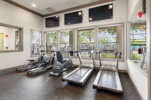 Gym with cardio machines and televisions