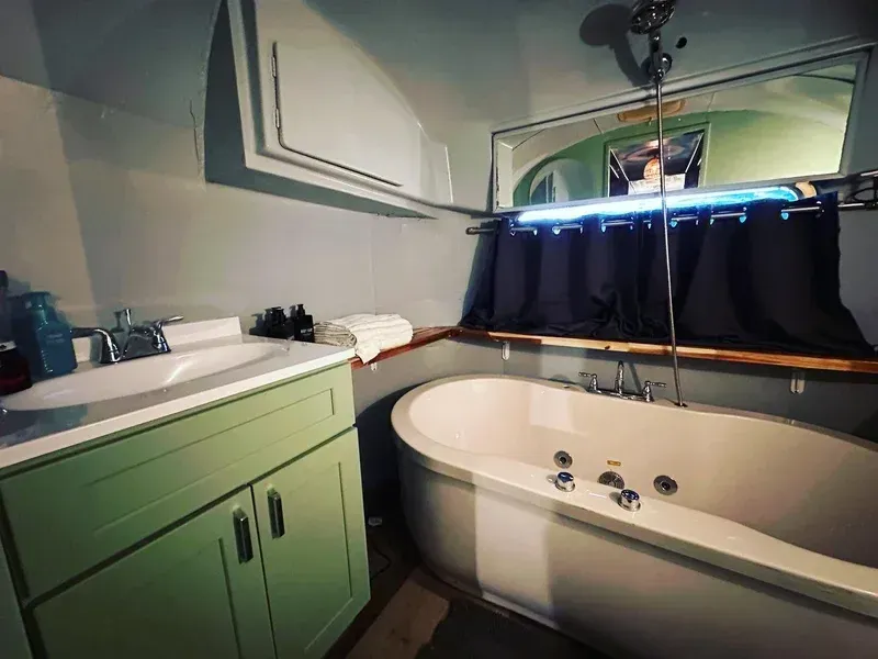 a bathroom with a tub , sink and mirror .