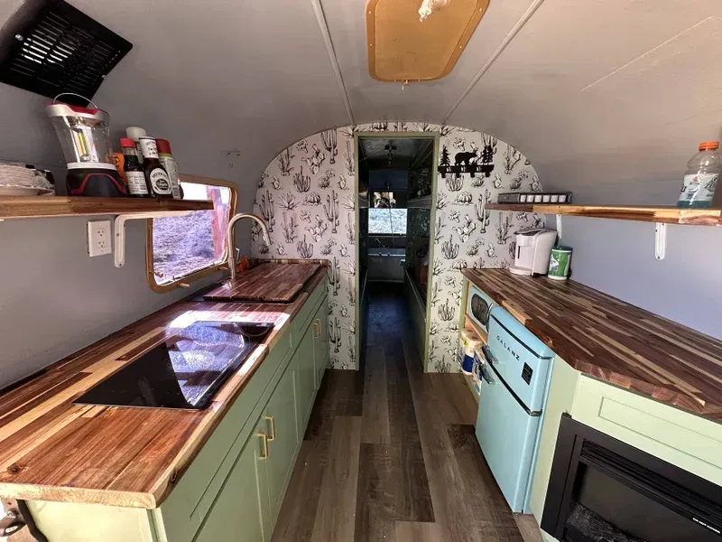 a kitchen with green cabinets and wooden counter tops .