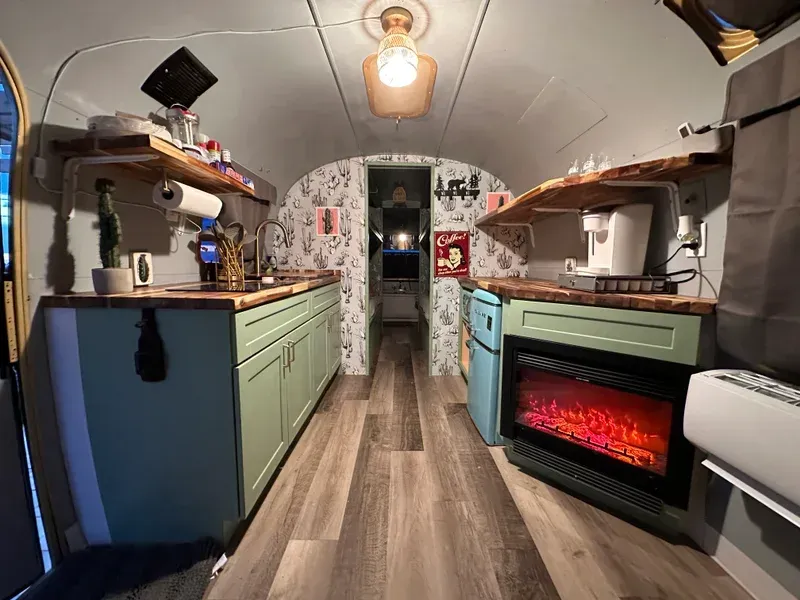 a kitchen in an airstream with a fireplace and a sink .
