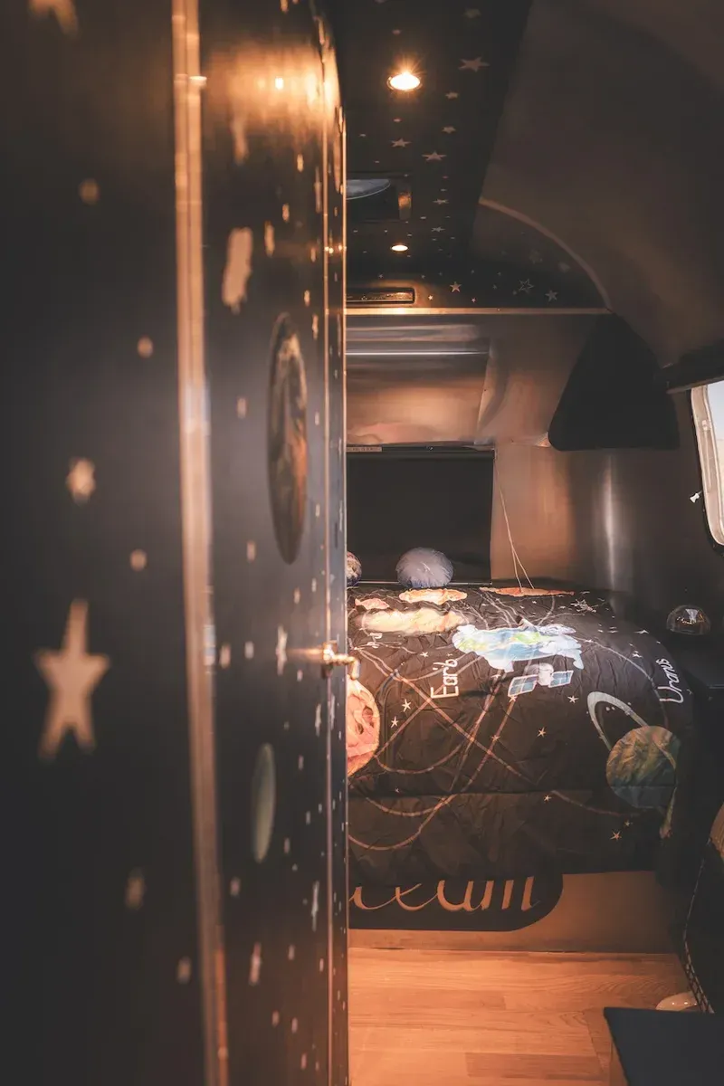 a bedroom with a bed and a door that looks like a space ship .