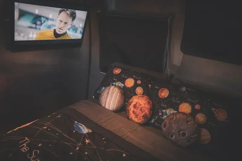 a bed with pillows and a television on the wall .