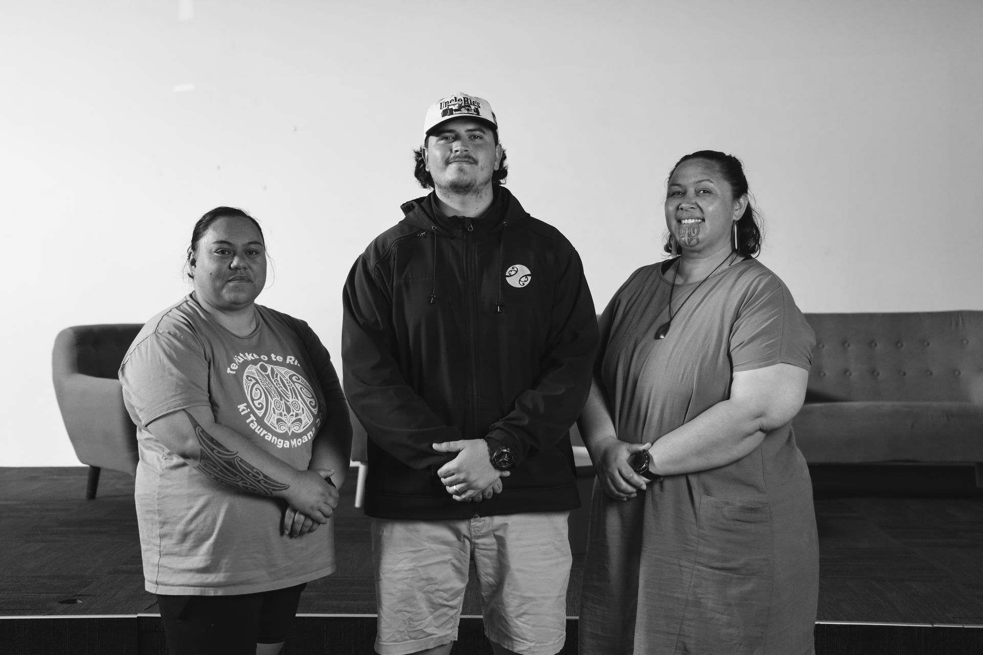 A man and two women are standing next to each other in a black and white photo.