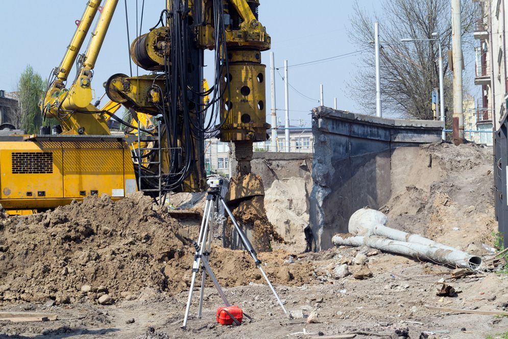 A Construction Site With a Yellow Excavator — Small Batch Concrete Delivery in Carrara, QLD