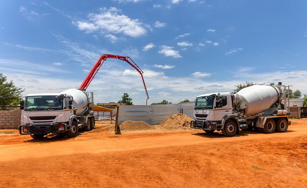 Two Concrete Mixer Trucks Are Parked Next to Each Other — Small Batch Concrete Delivery in Gold Coast, QLD