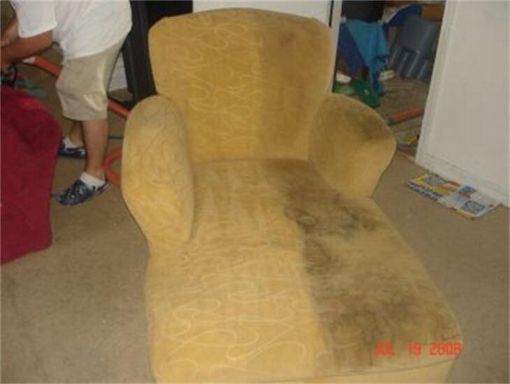 A dirty chair is sitting on the floor in a living room