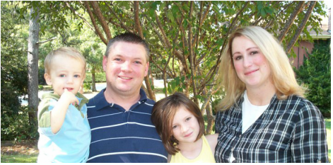A family posing for a picture with trees in the background
