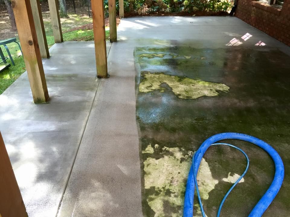 A hose is sitting on a dirty concrete floor.