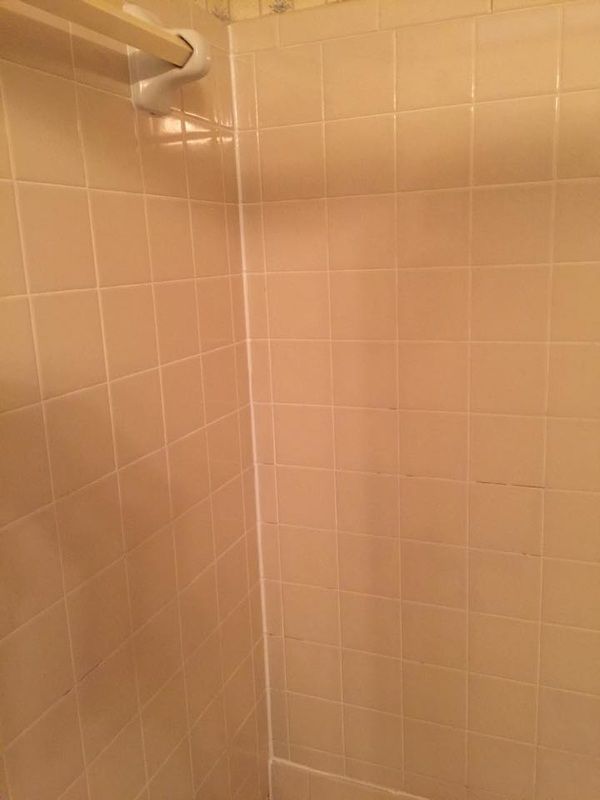 A bathroom with a shower stall and a towel rack.