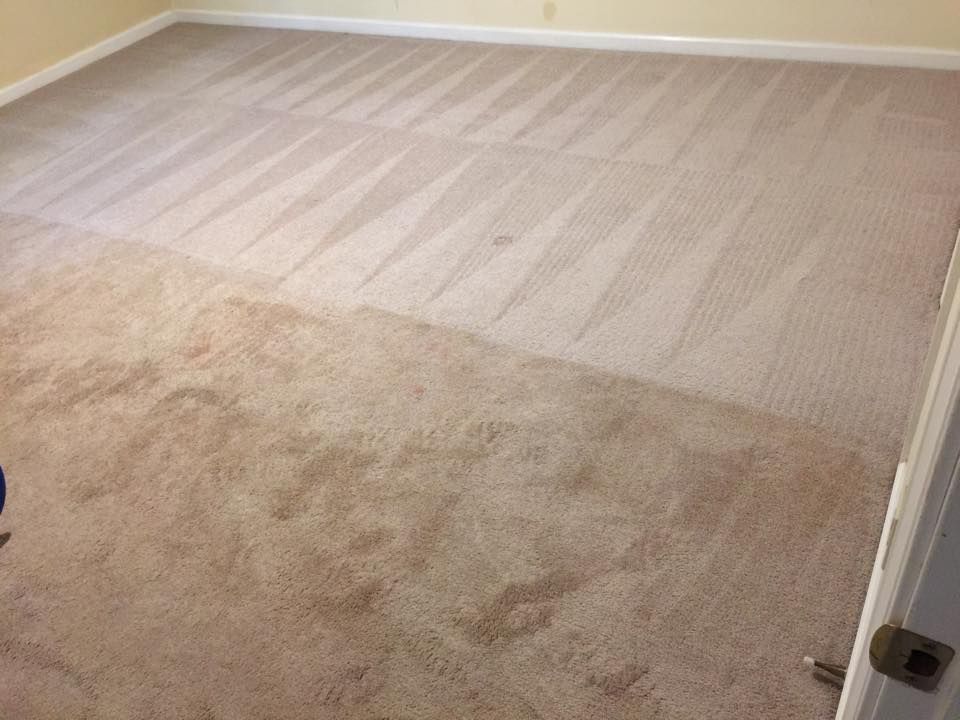 A room with a carpeted floor and a door.