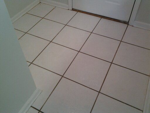 A tiled floor with a door in the background