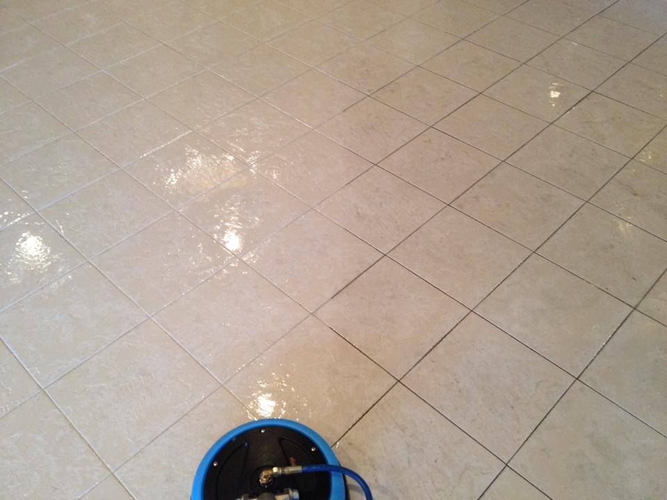 A blue bucket is sitting on a tiled floor