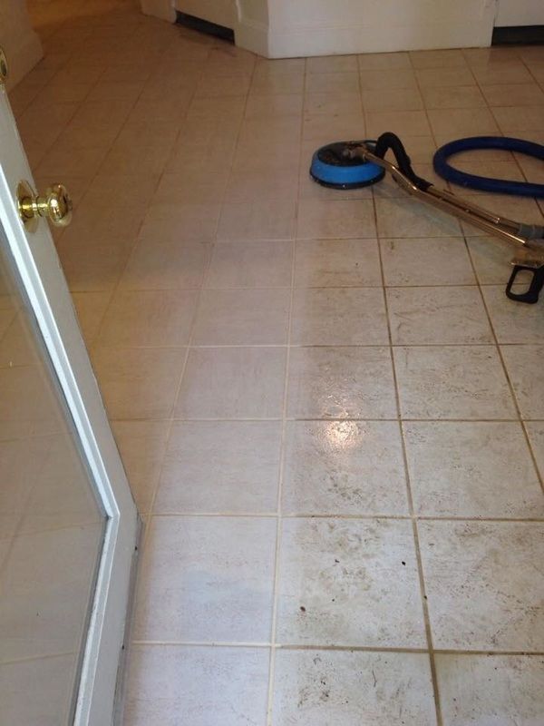 A vacuum cleaner is sitting on a tiled floor next to a door.