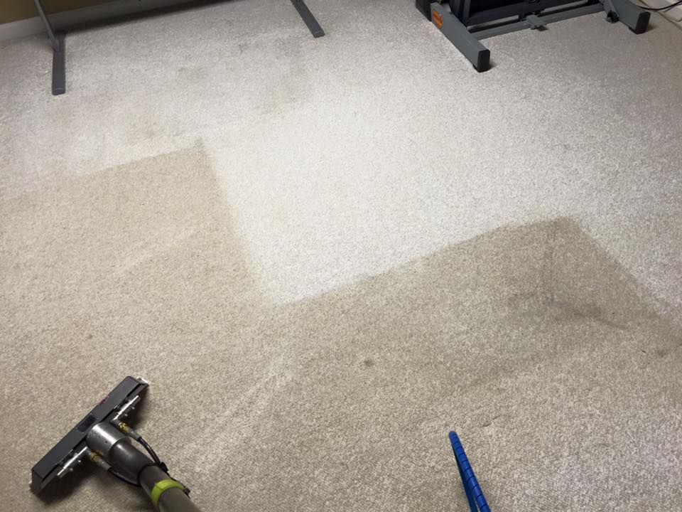 A vacuum cleaner is sitting on a dirty carpet in a room.