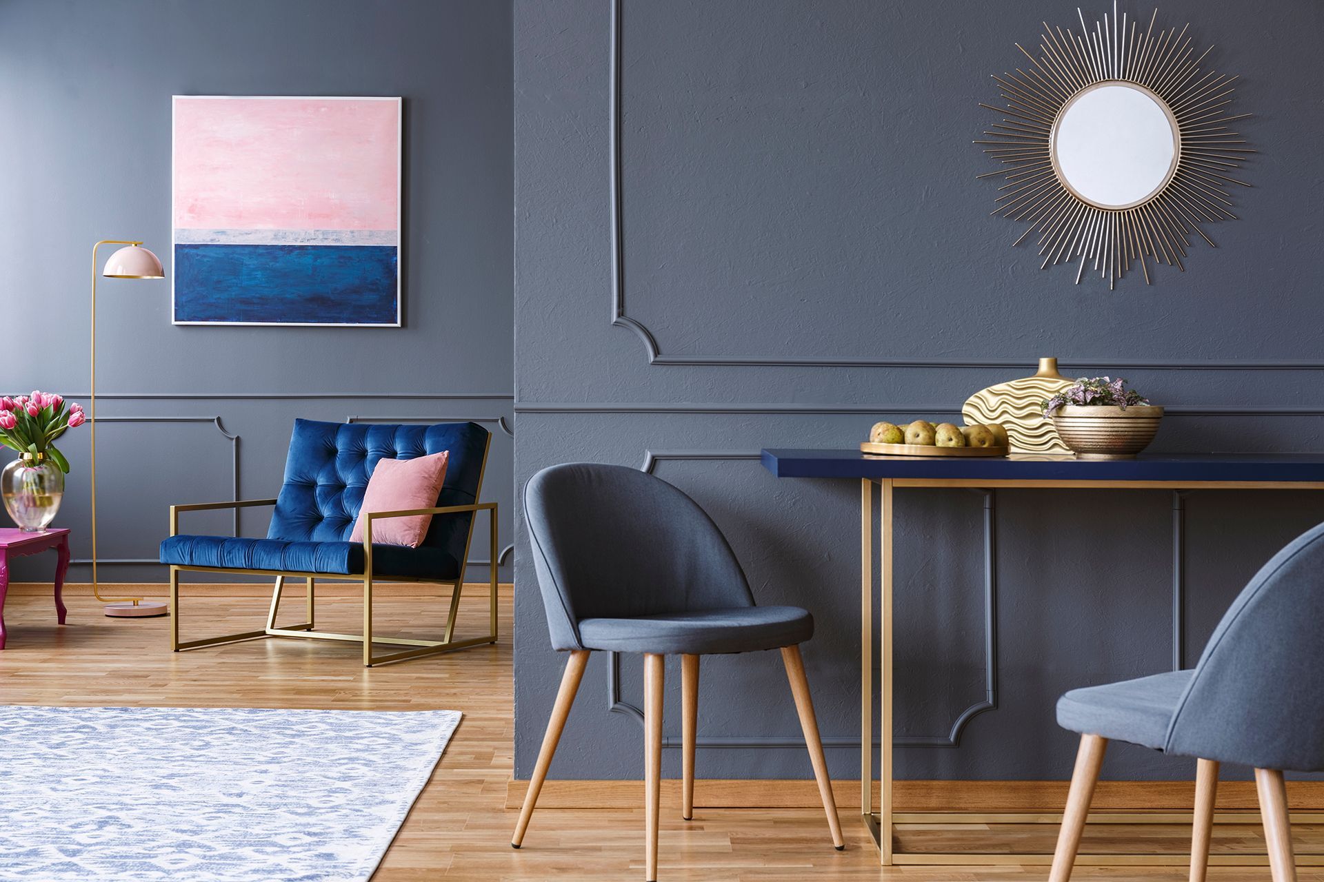 A living room with a table , chairs , and a painting on the wall.
