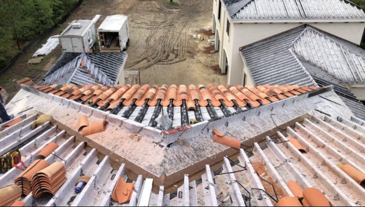 An aerial view of a roof with tiles being installed