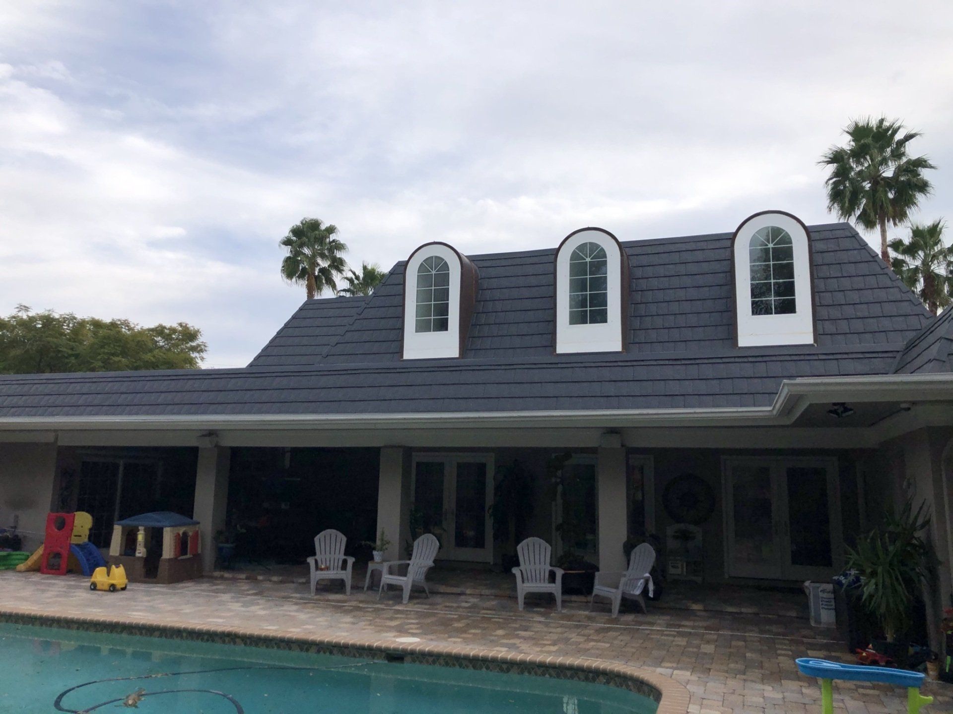 A large house with a swimming pool in front of it.