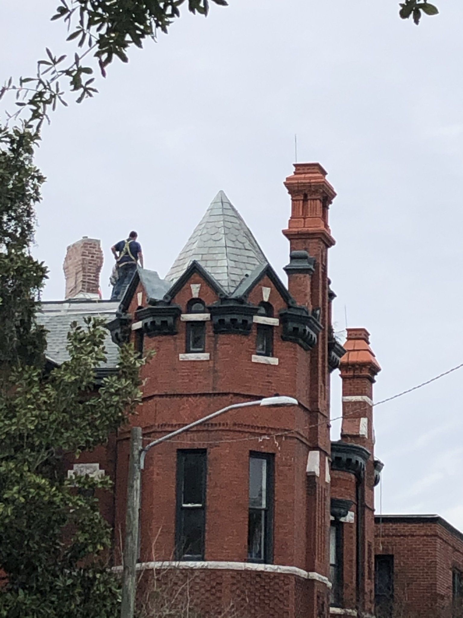 A man is standing on the roof of a brick building