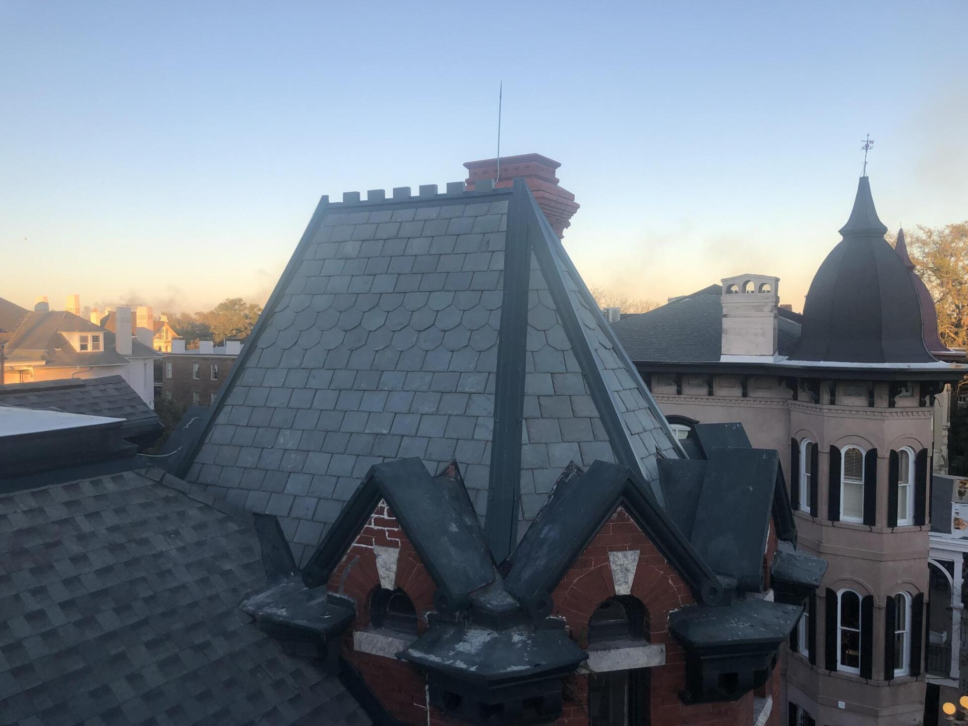 A brick building with a slate roof and a chimney