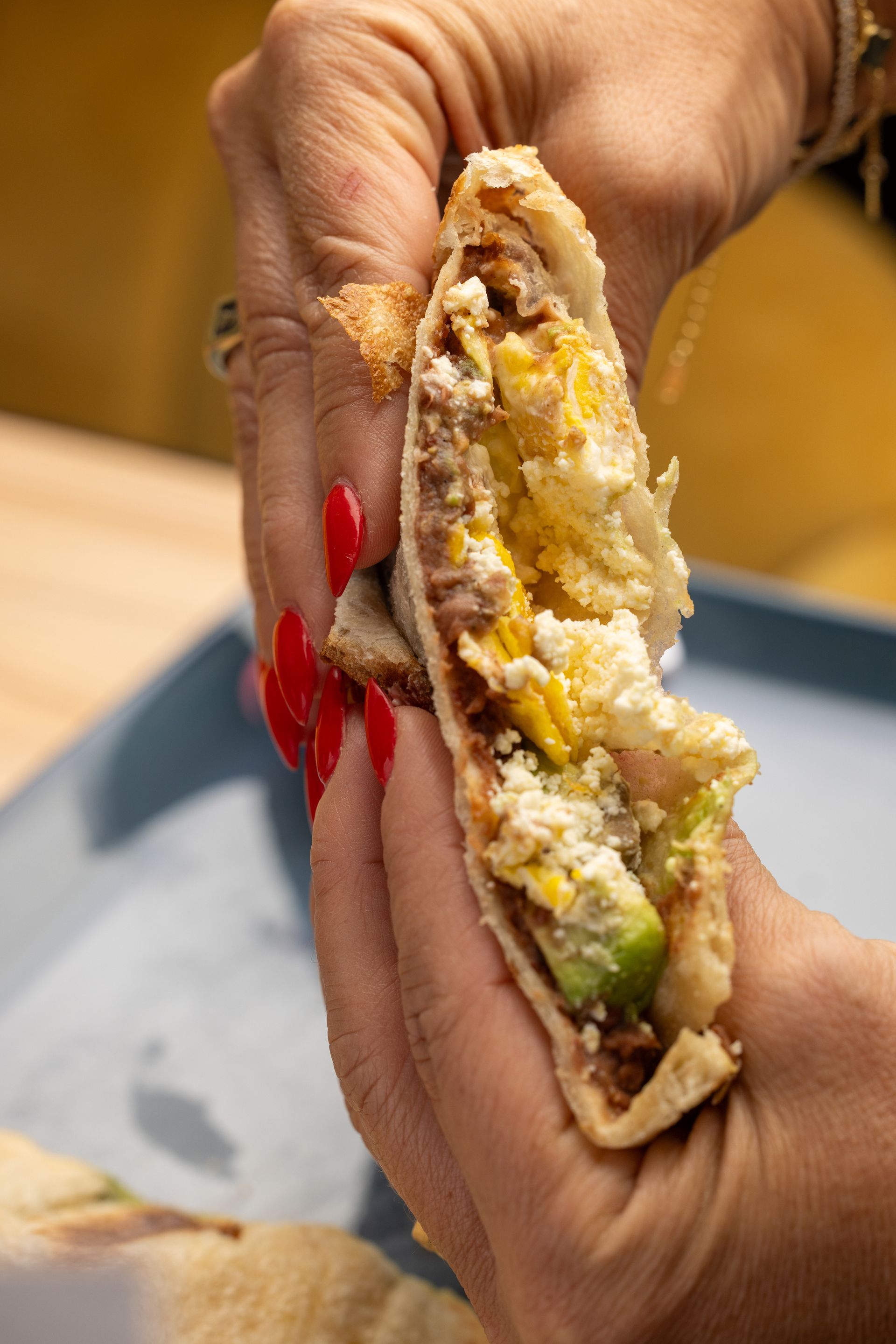 A close up of a person holding a sandwich in their hands.