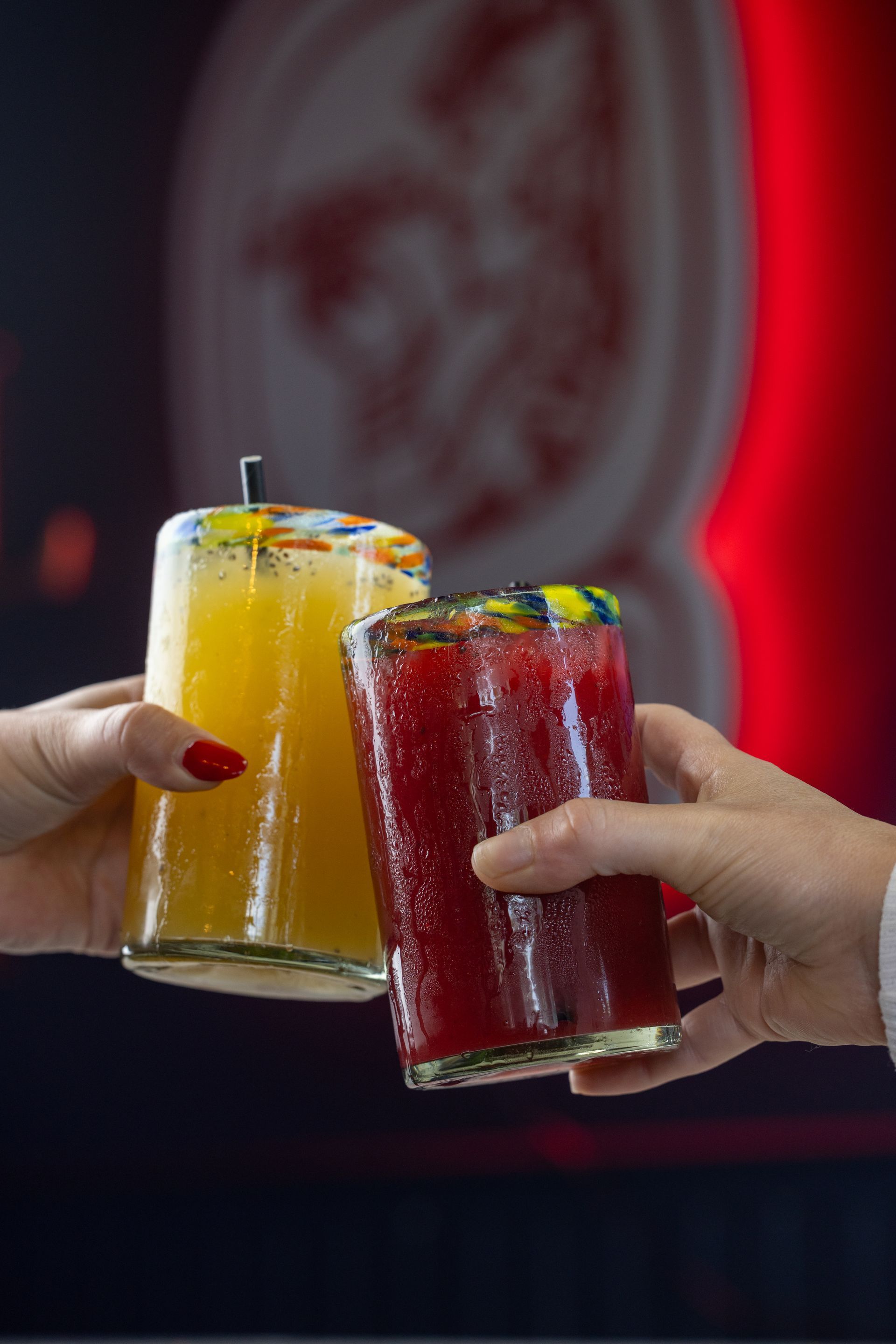 Two people are holding two drinks in their hands.