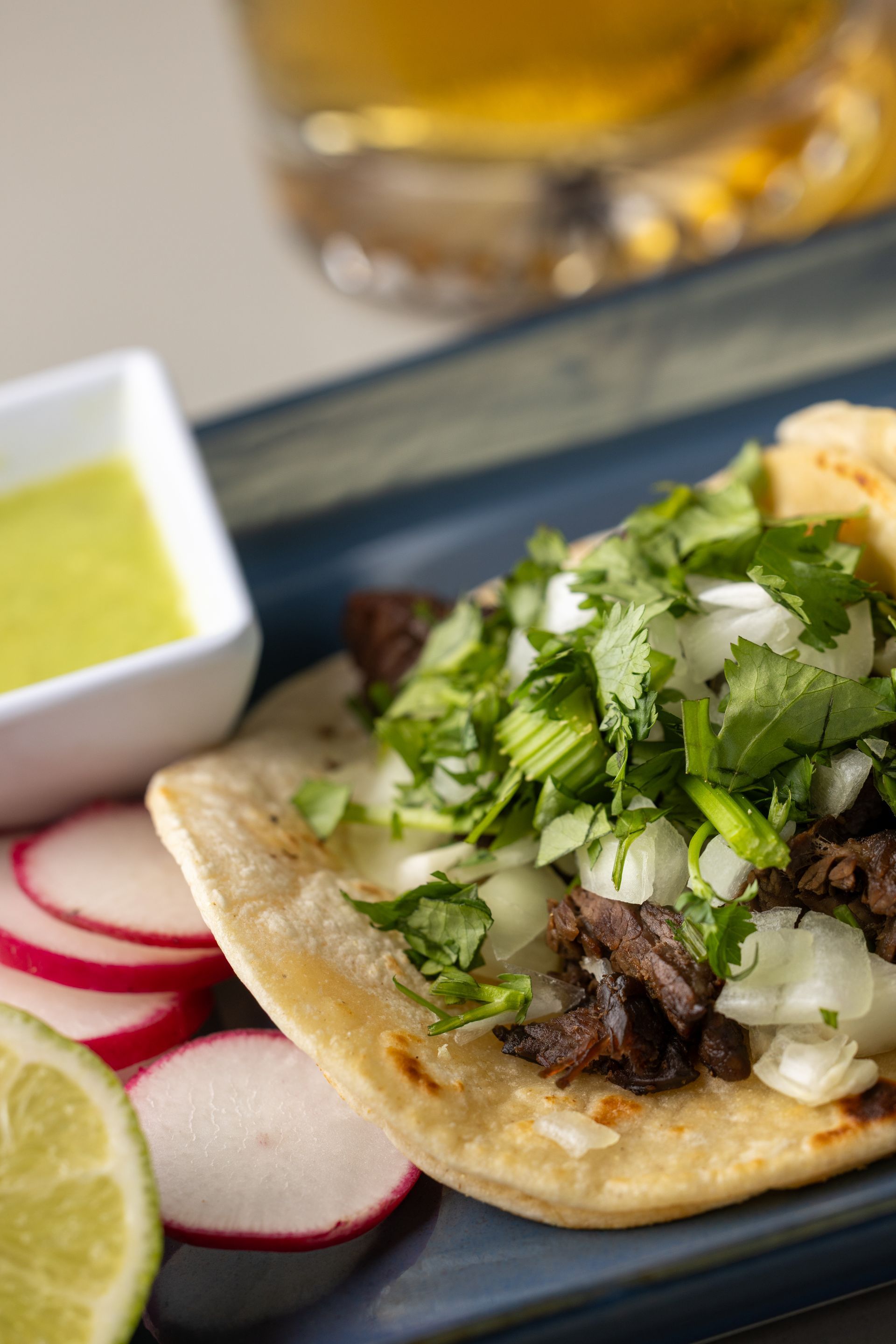 A close up of a taco on a plate with radishes and limes.