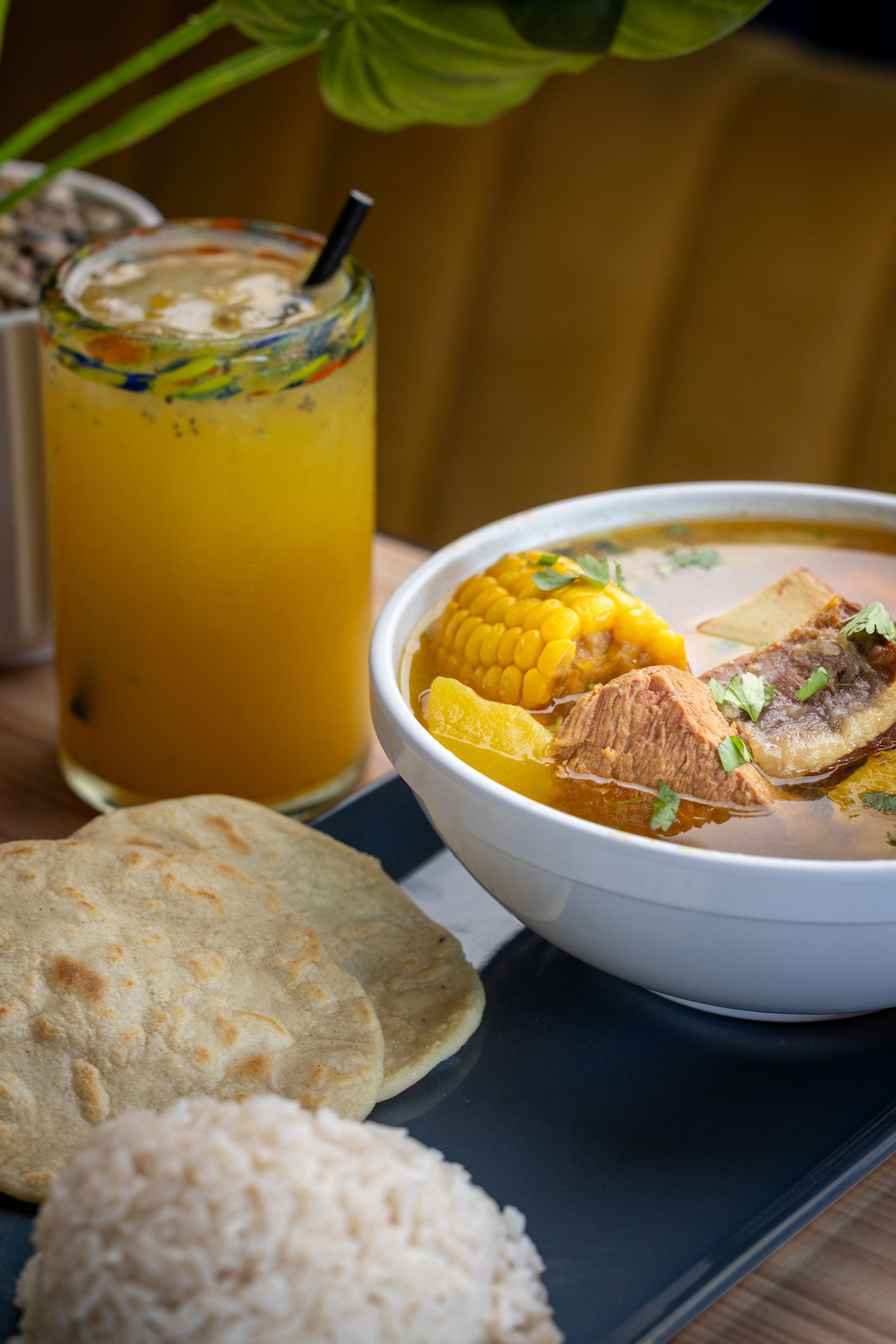 There is a bowl of soup and a drink on the table.
