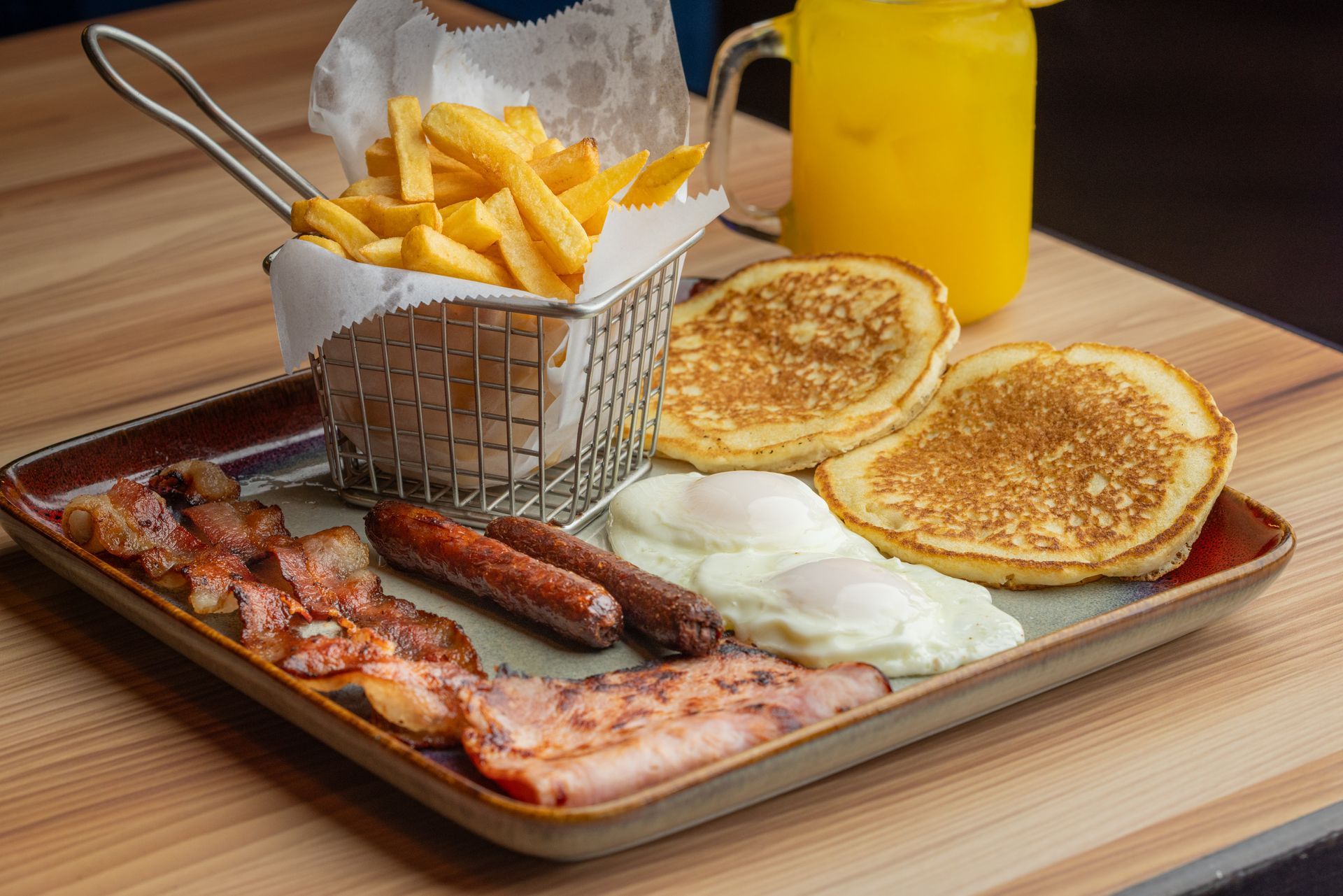 A white plate topped with a variety of food and a drink on a table.
