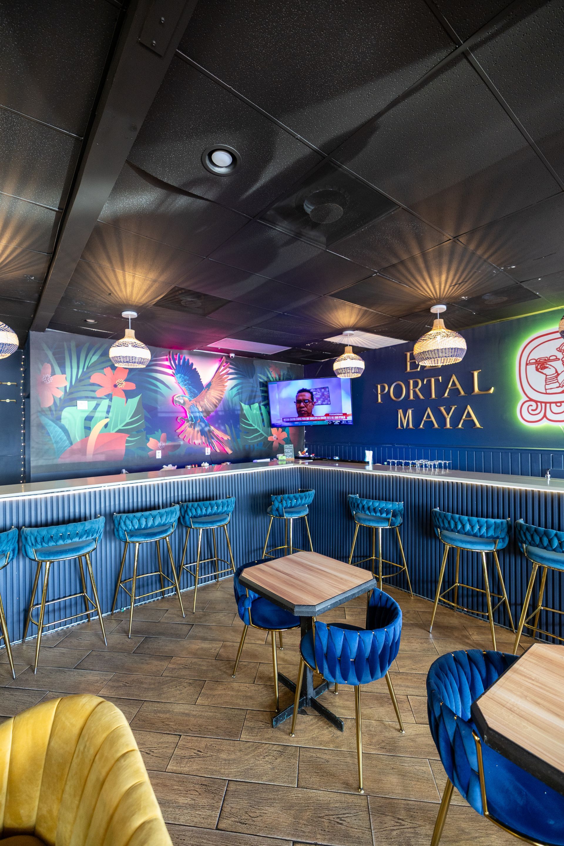 A restaurant with tables and chairs and a bar.