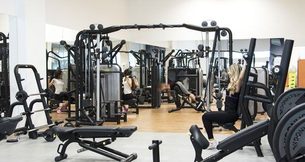 Žena sedi na klupi u teretani.