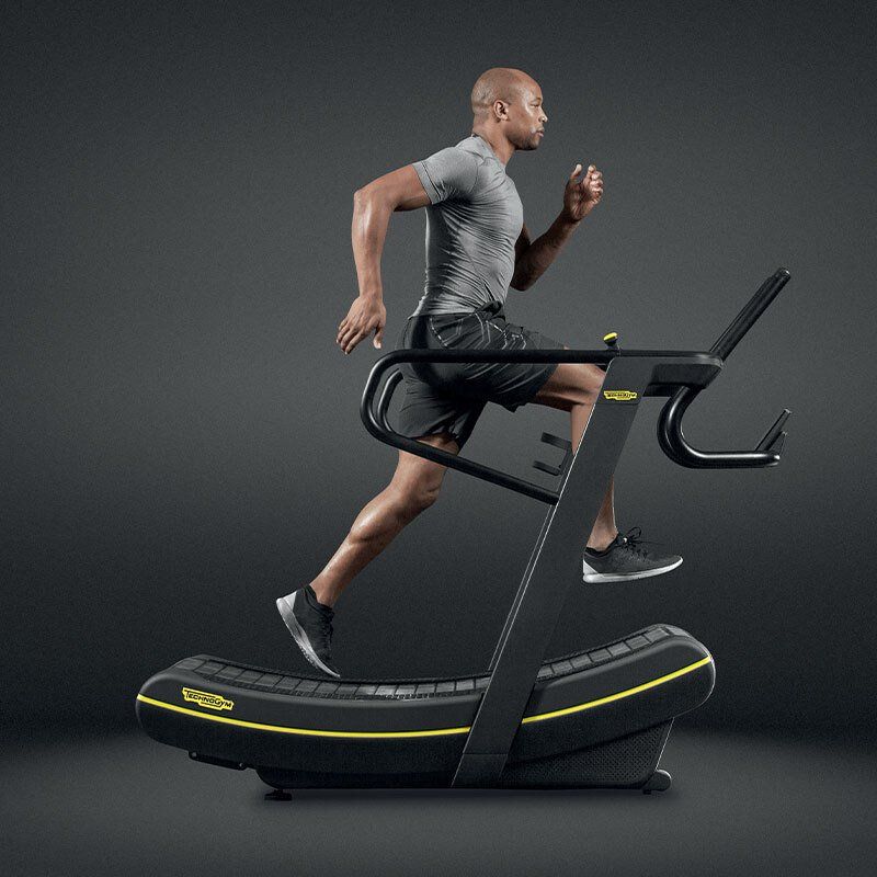 Muškarac trči na traci za trčanje u teretani.