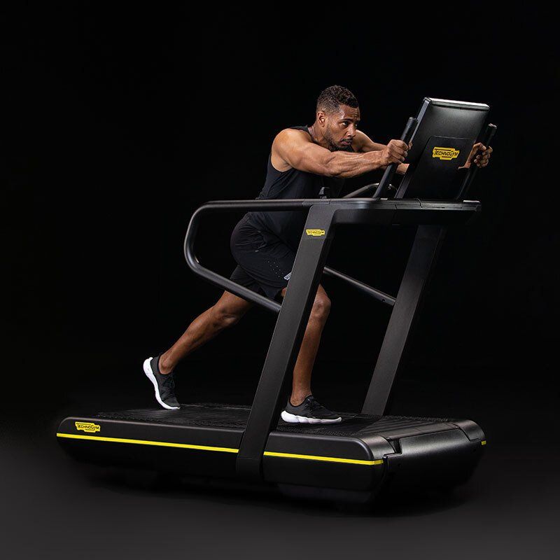 Muškarac trči na traci za trčanje u teretani.