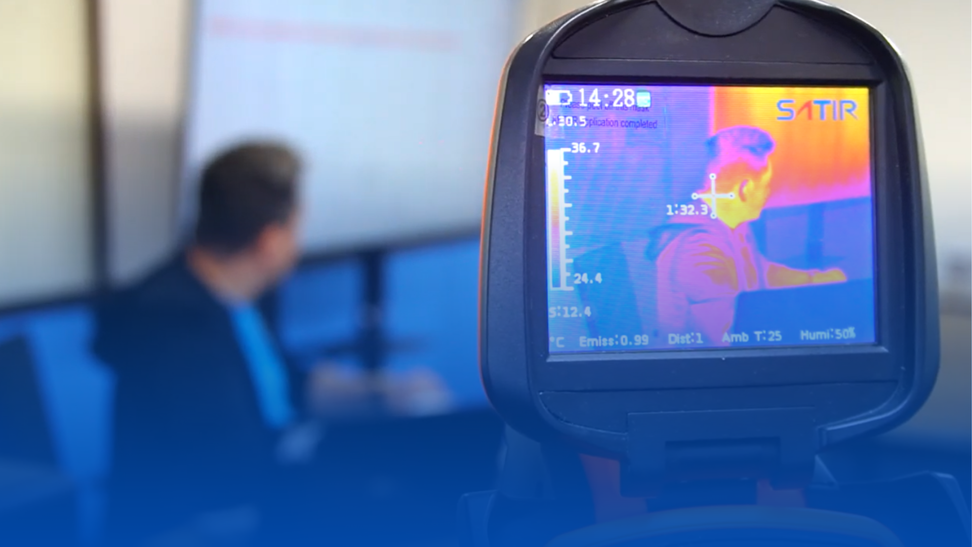 A man is giving a presentation in front of a group of people in a classroom.