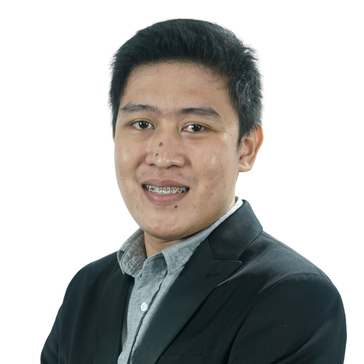 A man in a suit and braces is smiling for the camera