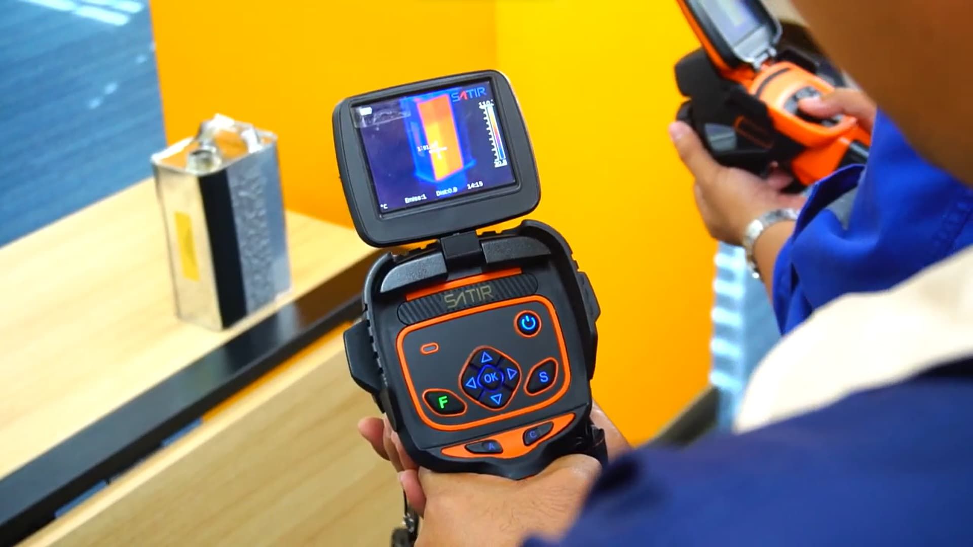 A man is holding a thermal camera in his hands.