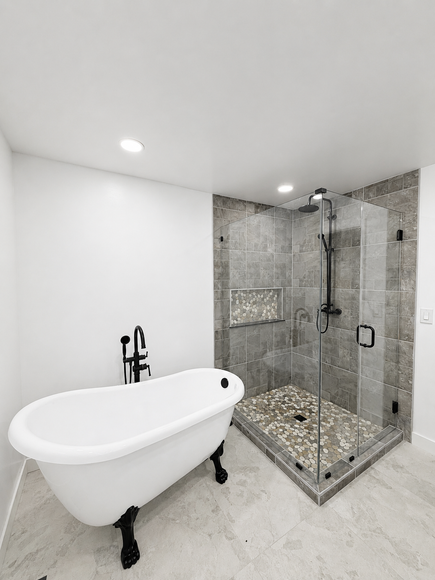 A bathroom with a walk in shower , sink and mirror.