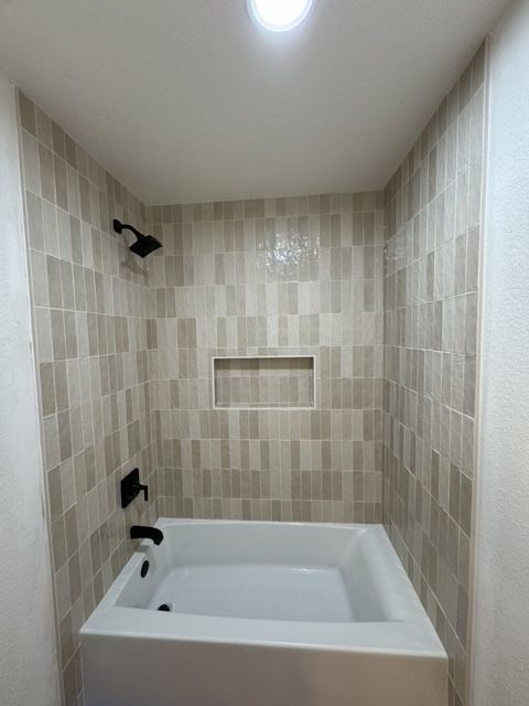 A bathroom with a tub , shower , and toilet.