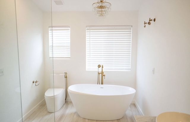 A bathroom with a tub , shower , and toilet.