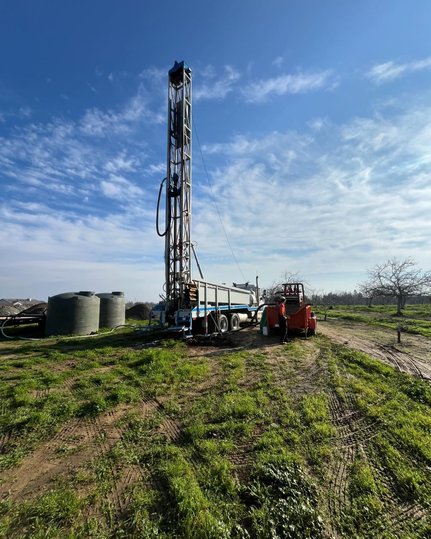 A large drilling rig is sitting in the middle of a grassy field.