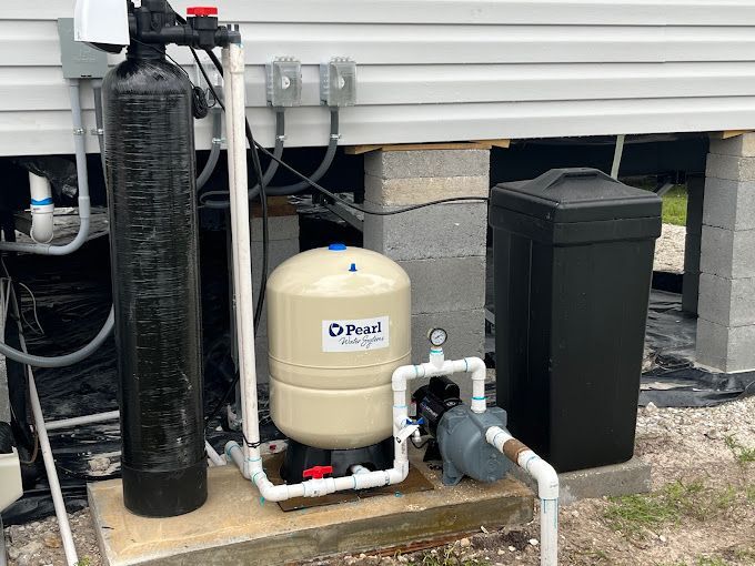 A water treatment system is installed on the side of a house.