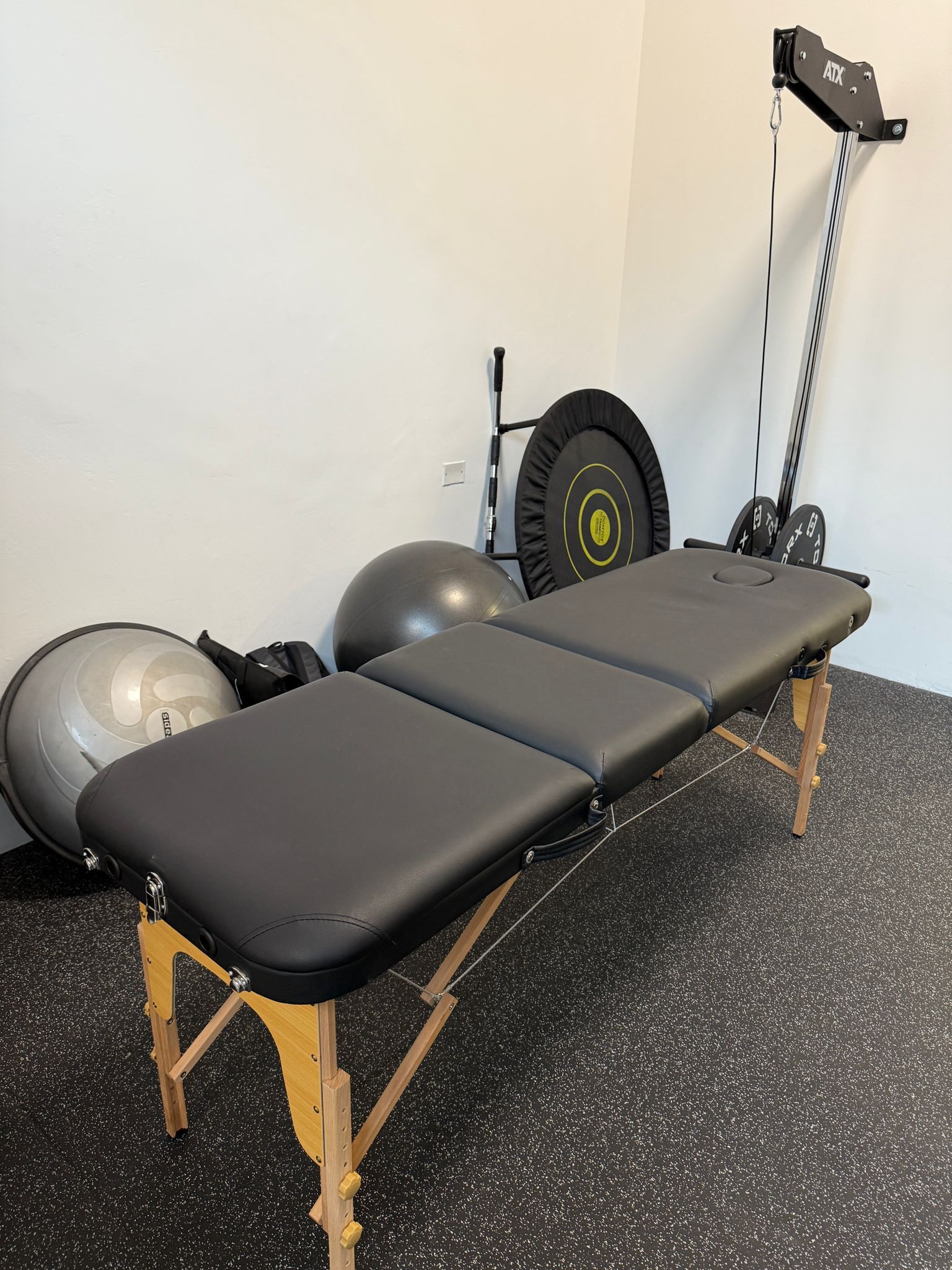 Una donna sta allungando le gambe su un foam roller in una palestra.