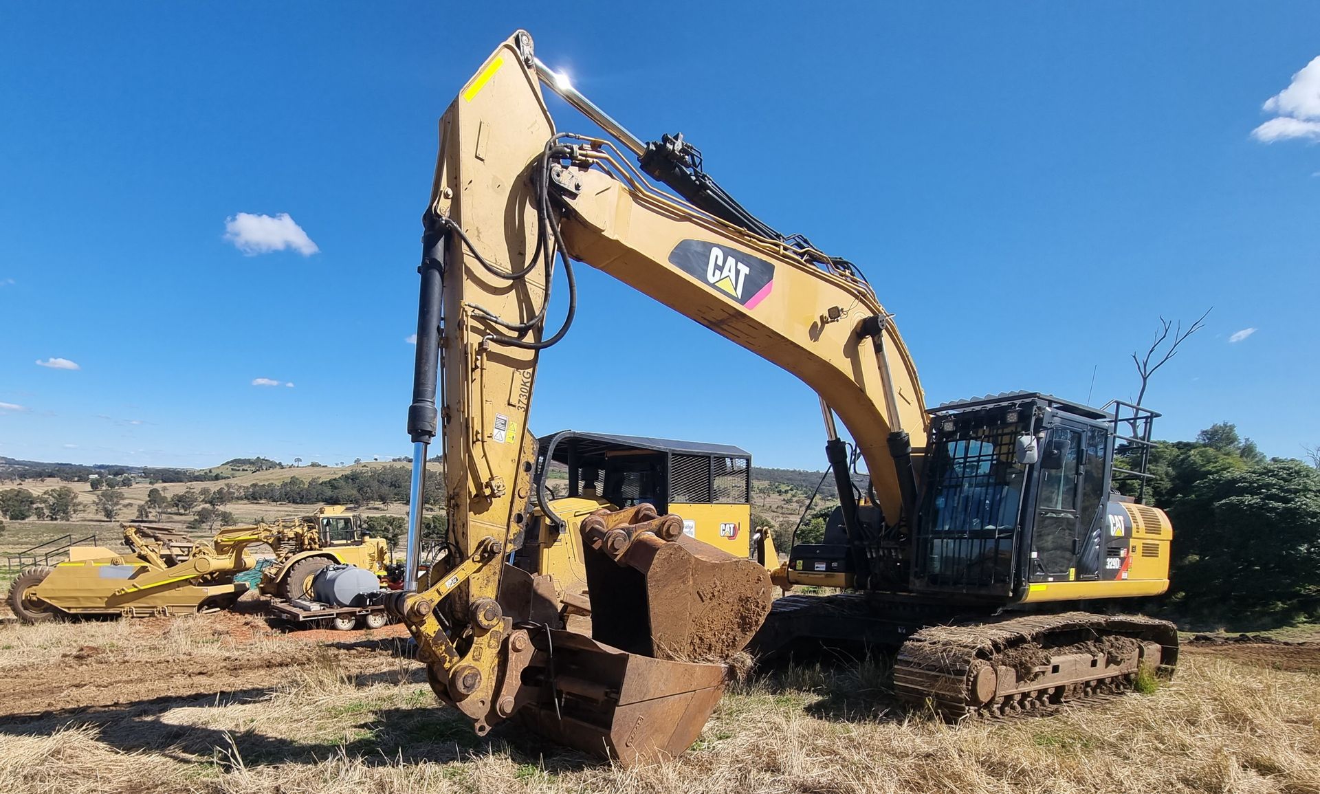 Yellow Excavator on a Dirt Lot Under a Blue Sky — Oakleigh Earthmoving in Cotswold Hills, QLD
