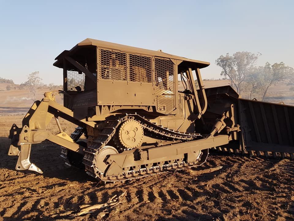 Yellow Bulldozer With a Front Blade and Cab, Parked on Muddy Ground — Oakleigh Earthmoving in Cotswold Hills, QLD