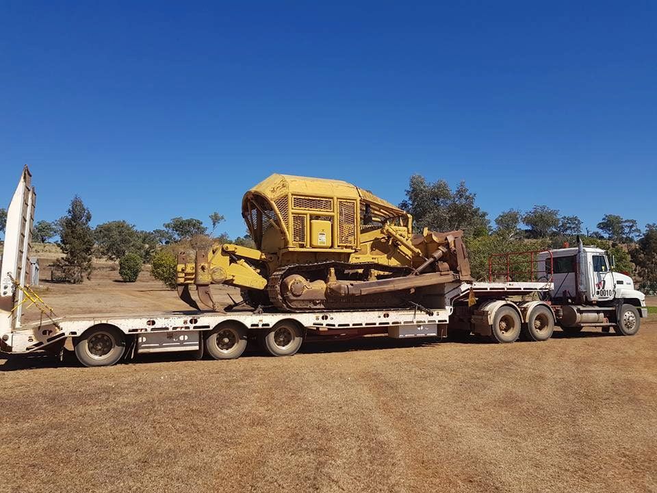 A Truck is Carrying a Bulldozer on a Flatbed Trailer — Oakleigh Earthmoving in Moonie, QLD