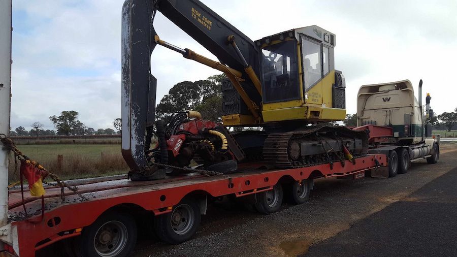 A Yellow and Black Excavator is on a Red Trailer — Oakleigh Earthmoving in Warwick, QLD