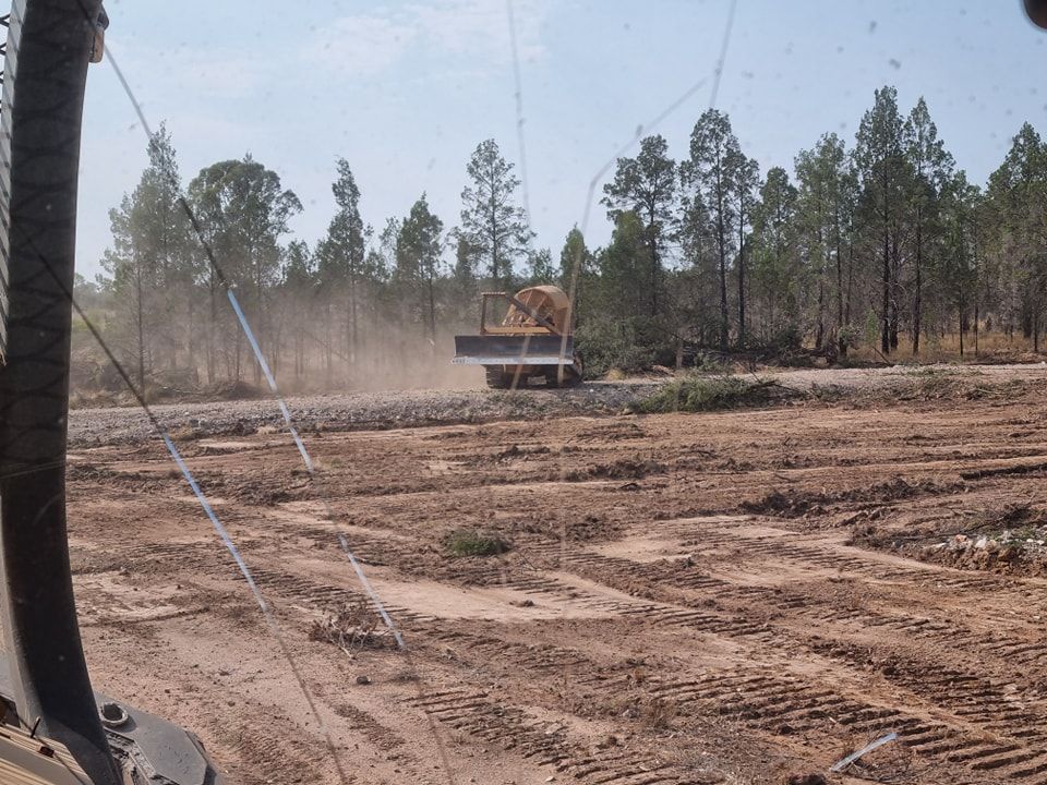 Dusty Construction Site With a Truck Driving Across Cleared Land — Oakleigh Earthmoving in Toowoomba, QLD