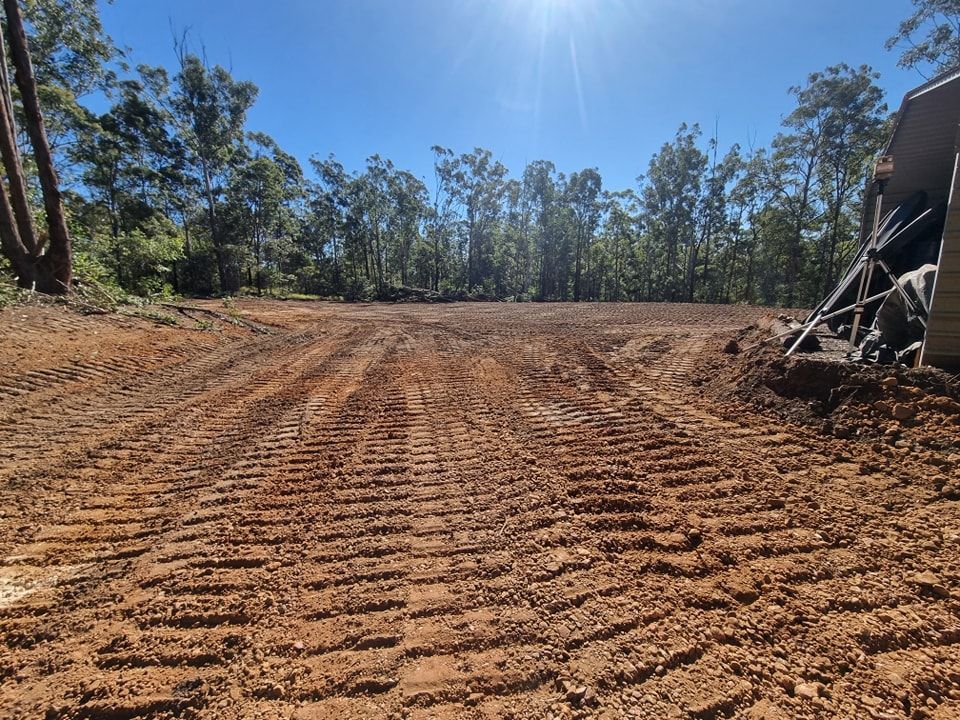 Cleared Dirt Lot With Tire Tracks Under a Bright Blue Sky — Oakleigh Earthmoving in Cotswold Hills, QLD