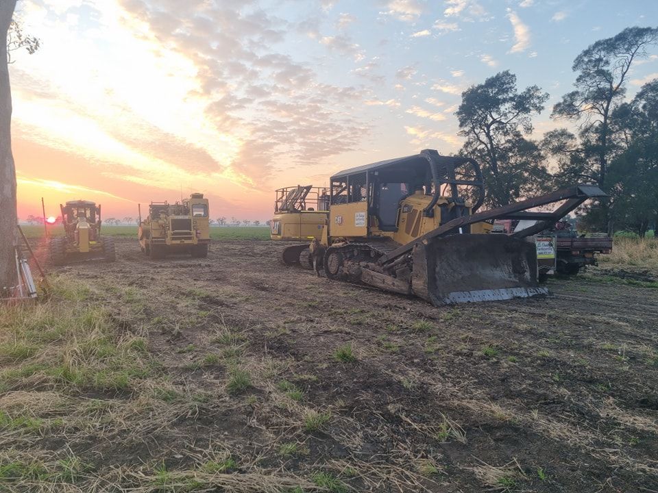 Bulldozers and Heavy Equipment at a Dirt Field During Sunrise or Sunset — Oakleigh Earthmoving in Kingaroy, QLD