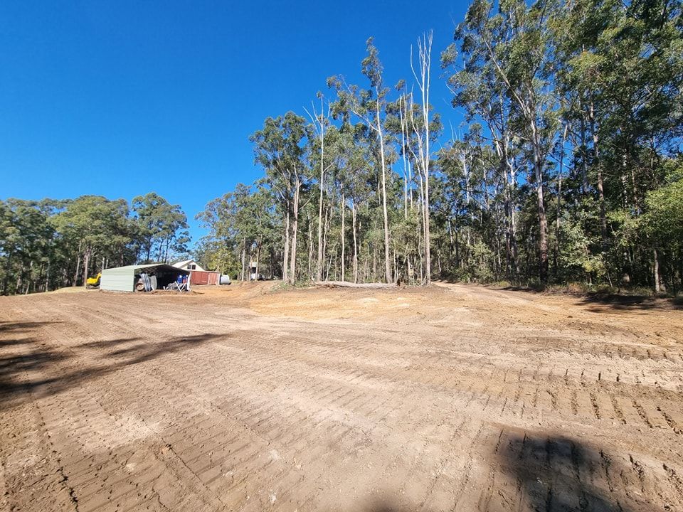 Cleared Dirt Lot Beside Trees and a Small Shed Under a Bright Blue Sky — Oakleigh Earthmoving in Kingaroy, QLD